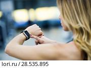 Young woman using smartwatch at the gym. Caucasian female working out. Стоковое фото, фотограф Javier Sánchez Mingorance / Ingram Publishing / Фотобанк Лори