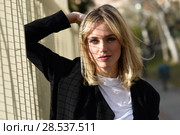 Beautiful blonde woman in urban background. Young girl wearing black blazer jacket standing in the street. Pretty female with straight hair hairstyle and blue eyes. Стоковое фото, фотограф Javier Sánchez Mingorance / Ingram Publishing / Фотобанк Лори