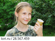 Улыбающаяся девочка со стаканчиком мороженого в руке в летнем парке. Стоковое фото, фотограф Круглов Олег / Фотобанк Лори