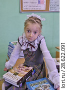 Удивленная девочка с новыми учебниками в школьном классе (2012 год). Редакционное фото, фотограф Илюхина Наталья / Фотобанк Лори