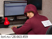 Интернет тролль у компьютера. Мужчина со злым лицом и надписью на спине : "Don't feed the troll" (Не кормите тролля) пишет гадости на форуме. Стоковое фото, фотограф Лариса Капусткина / Фотобанк Лори
