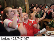 Москва, российские болельщики и девушка официант ликуют забитому голу во время серии пенальти матча Россия-Хорватия на Никольской улице (2018 год). Редакционное фото, фотограф Дмитрий Неумоин / Фотобанк Лори