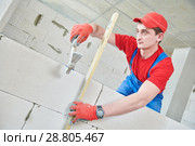 walling. bricklayer installing wall from autoclaved aerated concrete blocks. Стоковое фото, фотограф Дмитрий Калиновский / Фотобанк Лори