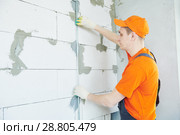 Plasterer installing screed on wall for plastering. Стоковое фото, фотограф Дмитрий Калиновский / Фотобанк Лори