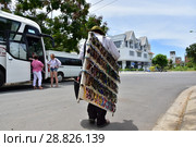 July 5, 2018. Nha Trang. Vietnam. Street vendor glasses a man in a female blue hat walking down the street. Many substandard goods and fakes are on sale. Offers goods to tourists. Редакционное фото, фотограф Евгений Бусурманов / Фотобанк Лори