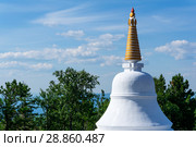 Upper part of the Buddhist stupa against the background of the sky and trees. Стоковое фото, фотограф Евгений Харитонов / Фотобанк Лори