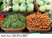 Green beans and carrots in wicker baskets on counter of vegetable store. Стоковое фото, фотограф Татьяна Яцевич / Фотобанк Лори