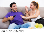 Woman trying to take away TV remote from boyfriend. Стоковое фото, фотограф Яков Филимонов / Фотобанк Лори