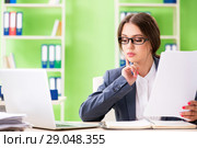 Young female employee very busy with ongoing paperwork. Стоковое фото, фотограф Elnur / Фотобанк Лори