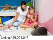 Дочка и мама мастерят фигурки из цветной бумаги, рядом спит кот. Стоковое фото, фотограф Иванов Алексей / Фотобанк Лори
