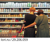 Покупательницы в молочном отделе супермаркета Selgros Cash & Carry в Зеленограде (2018 год). Редакционное фото, фотограф Сайганов Александр / Фотобанк Лори