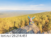 A man stands on a rock and opens his arms in breadth. Стоковое фото, фотограф Акиньшин Владимир / Фотобанк Лори