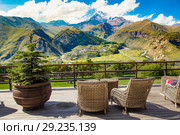 STEPANTSMINDA, GEORGIA - september 15, 2018: Beautiful view from terrace Rooms Hotel Kazbegi of the high mountain top Kazbek, Caucasus mountains and Gergeti Trinity Church Tsminda Sameba. Стоковое фото, фотограф Алексей Ширманов / Фотобанк Лори