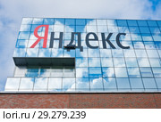 Надпись "Яндекс" на здании офиса компании. Облака отражаются в стеклянной поверхности здания. Москва. Россия (2018 год). Редакционное фото, фотограф E. O. / Фотобанк Лори