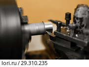 Turning a rotating workpiece on a old manual metalworking lathe, focus on the tip of the tool bit. Стоковое фото, фотограф Евгений Харитонов / Фотобанк Лори