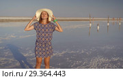 Slim sexy girl in white hat enjoying sunset, wooden salt pillars of a salt lake. Стоковое видео, видеограф Ирина Мойсеева / Фотобанк Лори