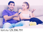 Woman trying to take away TV remote from boyfriend. Стоковое фото, фотограф Яков Филимонов / Фотобанк Лори