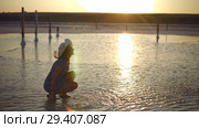 happy smiling girl enjoying sun, sprinkles salt water of lake in rays of sunset. Стоковое видео, видеограф Ирина Мойсеева / Фотобанк Лори