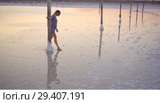 Calm girl enjoying sun, walking slowly through the water of a salt lake. Стоковое видео, видеограф Ирина Мойсеева / Фотобанк Лори