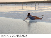 happy girl enjoying the sunset, touches water of a salt lake sitting on crystals. Стоковое фото, фотограф Ирина Мойсеева / Фотобанк Лори