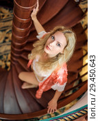 girl in silk robe stand on wooden spiral staircase. Стоковое фото, фотограф katalinks / Фотобанк Лори