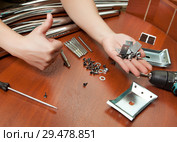A set of mounting material for the Assembly of the dining table and a hand showing the thumb. Стоковое фото, фотограф Элина Гаревская / Фотобанк Лори