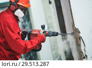 worker with demolition hammer removing plaster or stucco from wall. Стоковое фото, фотограф Дмитрий Калиновский / Фотобанк Лори