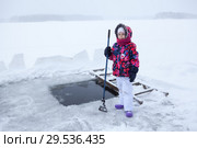 Маленькая девочка с ледорубом стоит у проруби на озере. Стоковое фото, фотограф Кекяляйнен Андрей / Фотобанк Лори