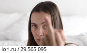 Woman showing middle finger in bedroom. Стоковое видео, видеограф Ekaterina Demidova / Фотобанк Лори