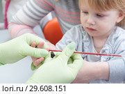 Blood medical test or research. Taking a blood sample from child finger in hospital. Стоковое фото, фотограф Дмитрий Калиновский / Фотобанк Лори