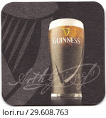 Бирдекель (подставка под пивную кружку) с рекламой английского пива «Guinness» («Гиннесс») Редакционное фото, фотограф Алексей Гусев / Фотобанк Лори