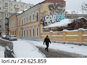 Прохожий на фоне усадебного дома в Колпачном переулке с видом на Покровку (2018 год). Редакционное фото, фотограф Дмитрий Неумоин / Фотобанк Лори