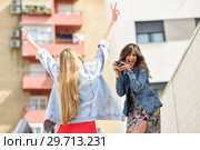 Two young tourist women taking photographs outdoors. Стоковое фото, фотограф Javier Sánchez Mingorance / Ingram Publishing / Фотобанк Лори