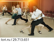 Adult pairs dancing tango movements in modern dance studio. Стоковое фото, фотограф Яков Филимонов / Фотобанк Лори