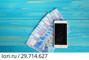 Смартфон с разбитым экраном и новые двухтысячные российские купюры на деревянном столе. Ремонт или покупка нового телефона. Стоковое фото, фотограф Наталья Гармашева / Фотобанк Лори
