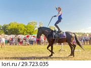 Russia, Samara, July, 2018: a Cossack girl rides a horse and performs tricks. Редакционное фото, фотограф Акиньшин Владимир / Фотобанк Лори