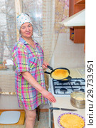 Mature woman bakes pancakes in the kitchen. Стоковое фото, фотограф Акиньшин Владимир / Фотобанк Лори