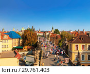 Top view of center of Prague with its red roofs and tourists on the Charles bridge, Prague, Czech Republic (2014 год). Редакционное фото, фотограф Наталья Волкова / Фотобанк Лори