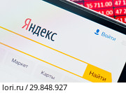 Поисковая система «Яндекс». Фрагмент страницы на экране мобильного телефона на фоне столбиков с числами (2019 год). Редакционное фото, фотограф E. O. / Фотобанк Лори