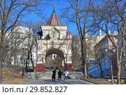 Туристы осматривают Триумфальную (Николаевскую) арку Цесаревича в солнечный зимний день. Владивосток (2019 год). Редакционное фото, фотограф Овчинникова Ирина / Фотобанк Лори