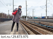 Девушка на перроне железнодорожной станции высматривает поезд вдалеке. Стоковое фото, фотограф Кекяляйнен Андрей / Фотобанк Лори