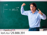 Young male physic standing in front of the green board. Стоковое фото, фотограф Elnur / Фотобанк Лори