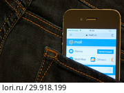 Cайт Mail.Ru на экране сотового телефона. Смартфон лежит в заднем кармане джинсовых штанов (2019 год). Редакционное фото, фотограф E. O. / Фотобанк Лори