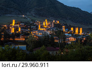Mestia at twilight, illuminated Svan towers on the background of a mountain slope, Upper Svaneti, Georgia (2018 год). Стоковое фото, фотограф Юлия Бабкина / Фотобанк Лори