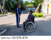 Разговор мужчины с пожилым инвалидом в городском парке (2018 год). Редакционное фото, фотограф Вячеслав Палес / Фотобанк Лори
