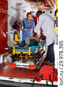 confident afro paramedical using defibrillator for providing medical care to patient. Стоковое фото, фотограф Яков Филимонов / Фотобанк Лори