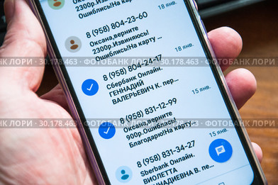 Смартфон с мошенническими сообщениями в руке (2019 год). Редакционное фото, фотограф Алёшина Оксана / Фотобанк Лори