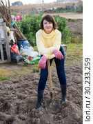 Girl in a yellow sweater digs beds with a shovel. Стоковое фото, фотограф Яков Филимонов / Фотобанк Лори