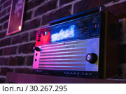 Советский транзисторный переносной радиоприемник "Океан 209" (в боке) в темном интерьере с неоновой подсветкой (2018 год). Редакционное фото, фотограф Кузин Алексей / Фотобанк Лори