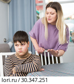 Mother and offended son arguing in domestic interior. Стоковое фото, фотограф Яков Филимонов / Фотобанк Лори